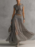Set grigio con top a pannelli in pizzo trasparente e gonna maxi plissettata