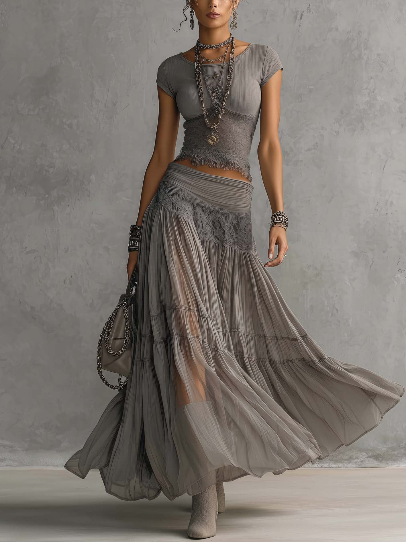 Set grigio con top a pannelli in pizzo trasparente e gonna maxi plissettata