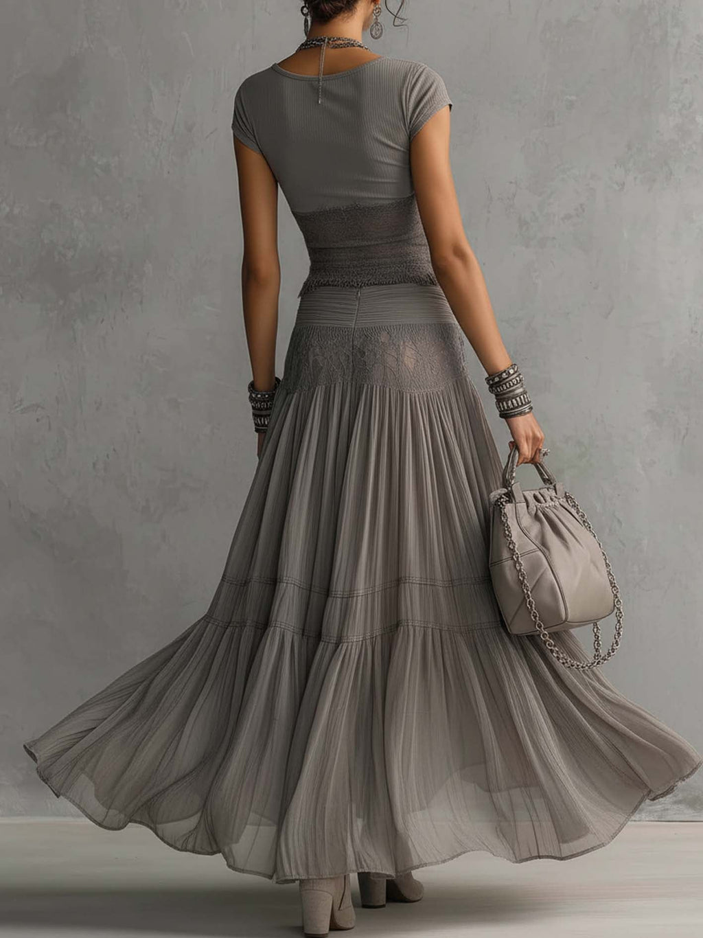 Set grigio con top a pannelli in pizzo trasparente e gonna maxi plissettata