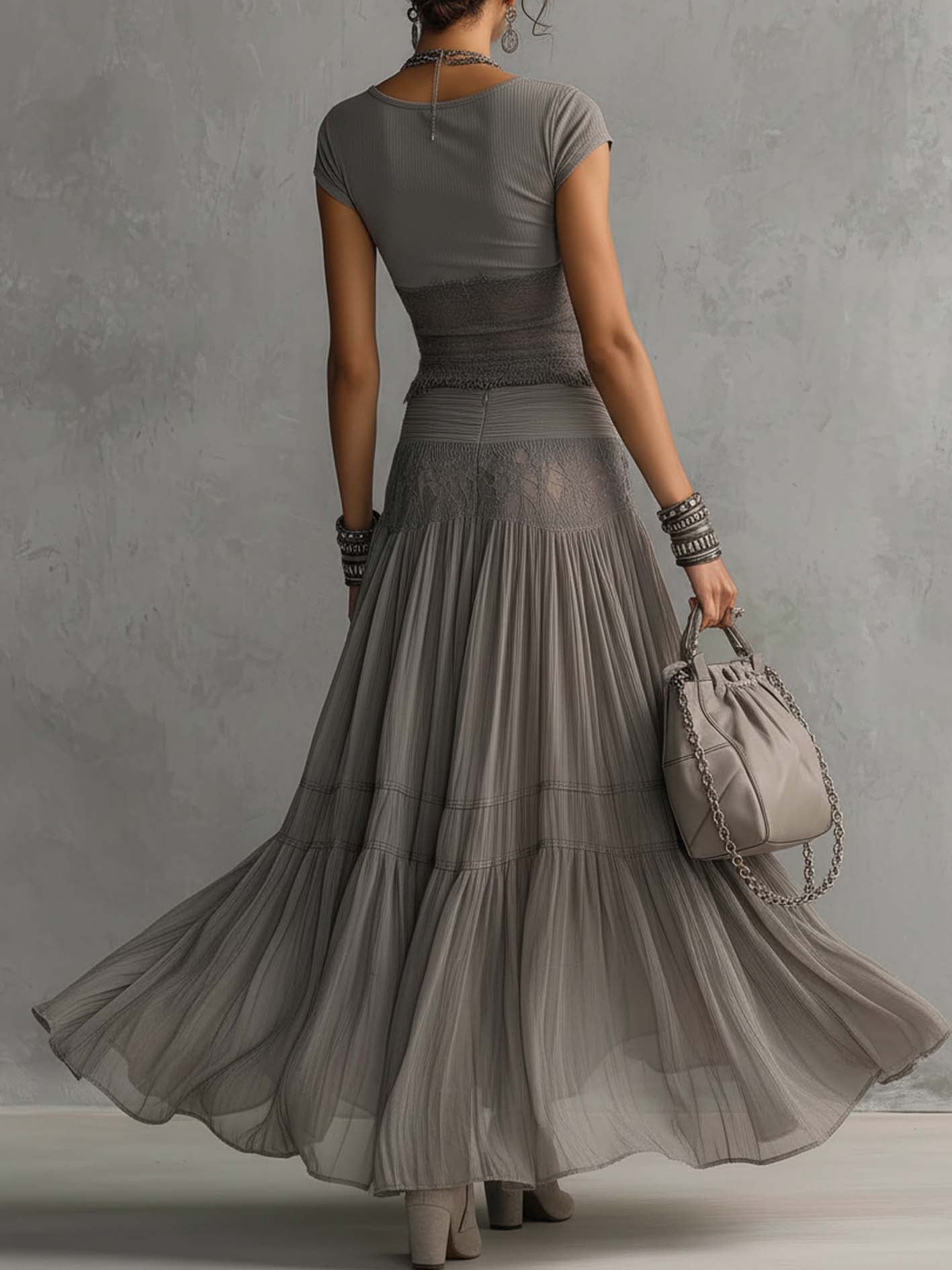 Set grigio con top a pannelli in pizzo trasparente e gonna maxi plissettata