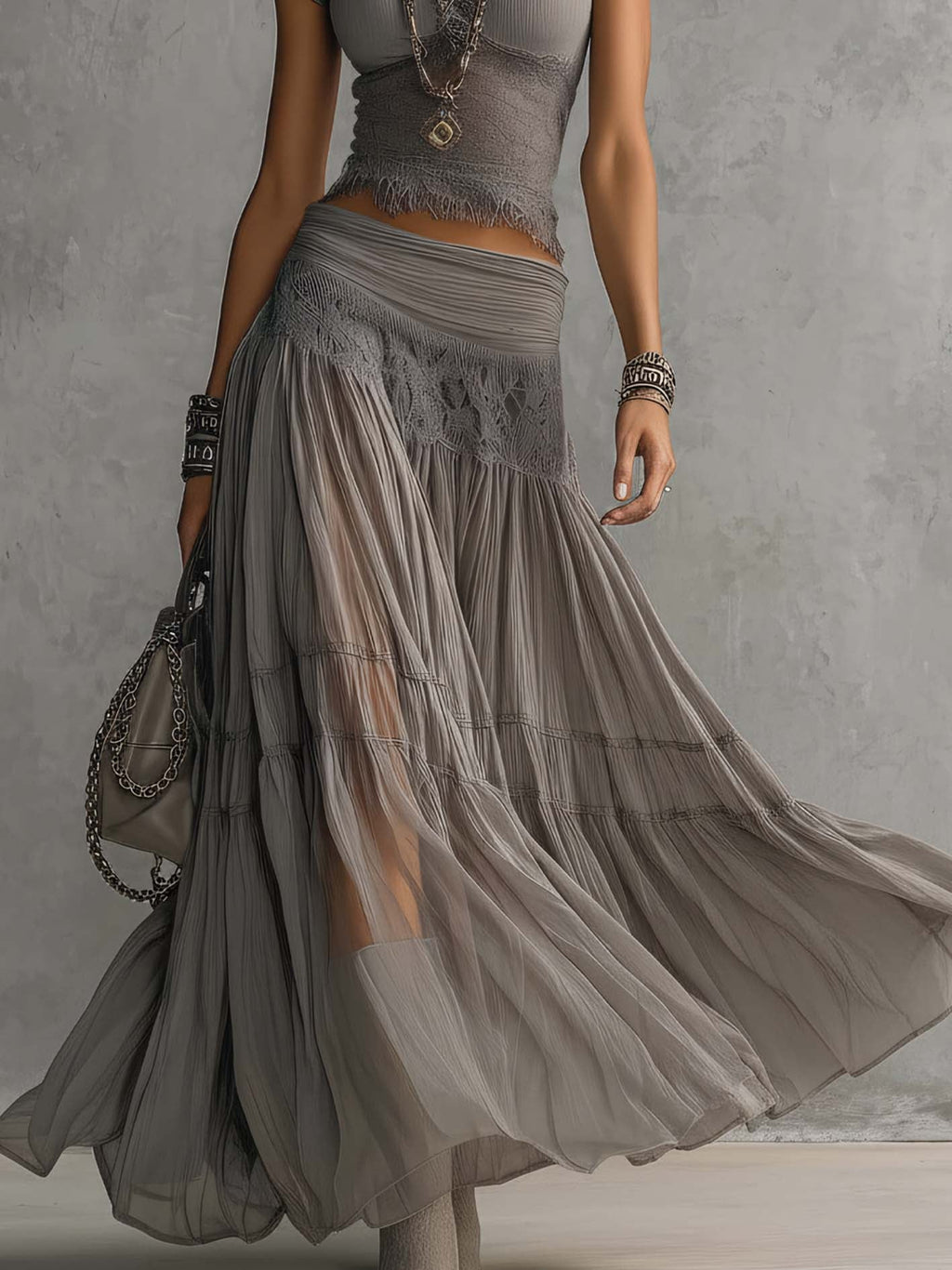 Set grigio con top a pannelli in pizzo trasparente e gonna maxi plissettata
