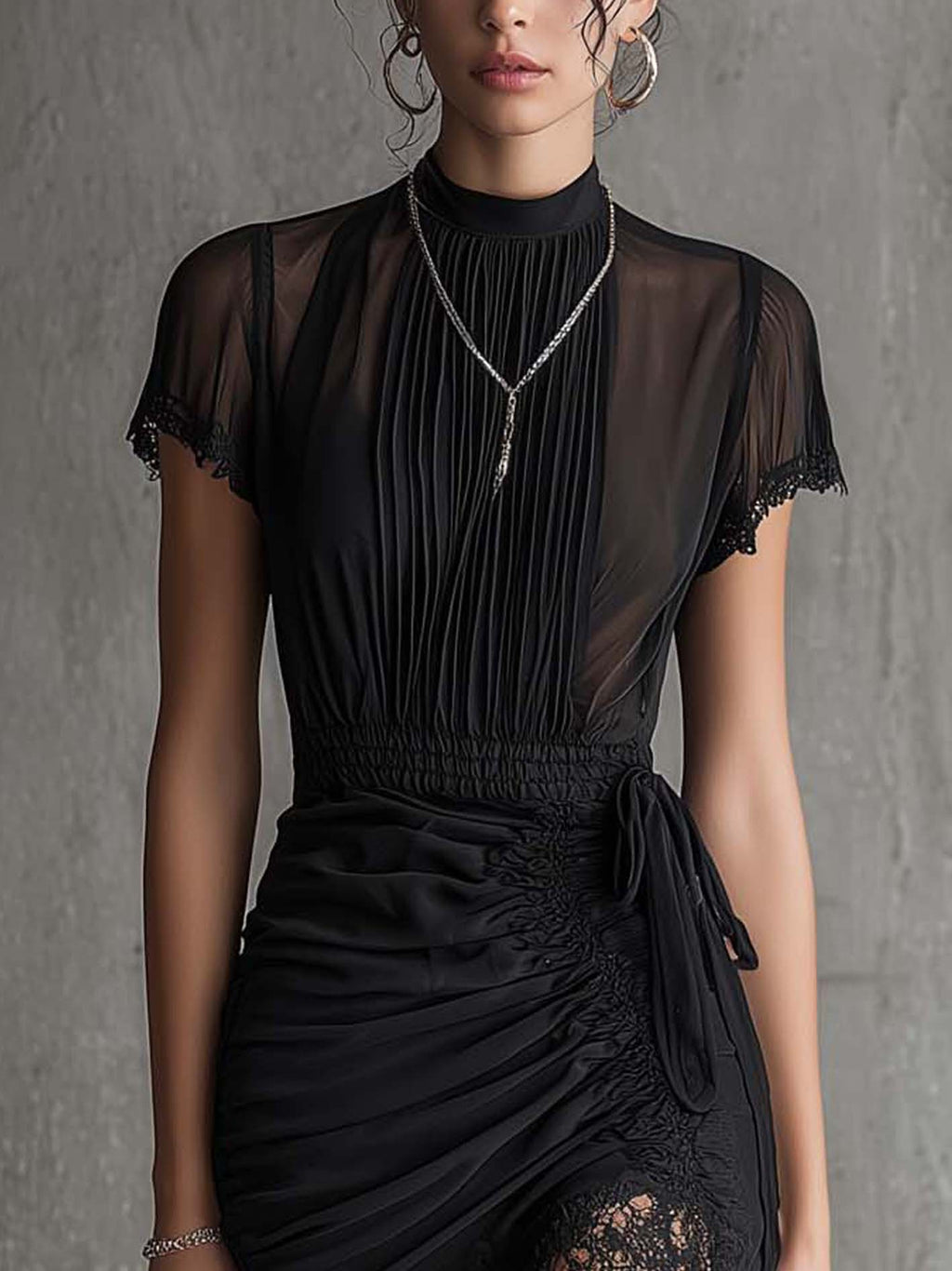 Mini abito nero in chiffon con vita plissettata e bordo in pizzo